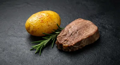 Gros plan sur une pomme de terre rôtie et une tranche de langue de bœuf