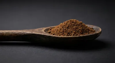 Cuillère de mesure contenant du fond de veau en poudre sur fond sombre