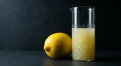 Citron jaune et doseur de jus sur fond sombre contrasté.