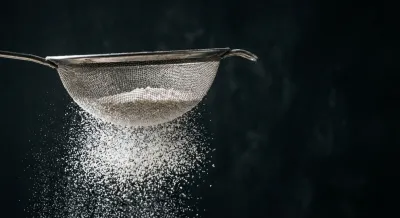 Gros plan contrasté de sucre glace tamisé, rendu iconique